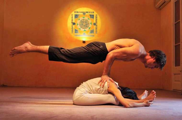 Alumnos practicando yoga en pareja, intensivo de verano